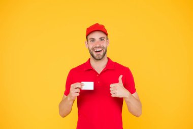 Pizza teslimatçısı kartvizit tutuyor. Adam kurtarıcıya ödeme yapar. Banka kartıyla öde. Ölümcül ödeme metodları. Teslimat konsepti. Kırmızı üniformalı, başparmağı havada bir postacı. En iyi servis.