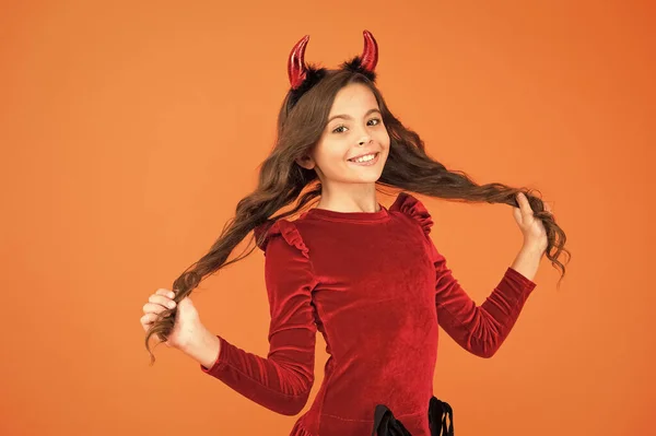 美しい小さなインプ女の子の赤い角はハロウィンを祝う。カーニバルのコンセプト。インプスタイルのアクセサリーハロウィンパーティーを持つ小さな子供。トリックや治療。超自然的な人物の後に設計されたハロウィーンの衣装 — ストック写真