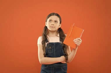 okul kız turuncu arka planda kitap okuyun. notları yazma. Çocuk günlüğü. şiir ve Roman. Modern eğitim. Notebook ile küçük kız düşünme. Edebiyat dersi. geri okula. Kız kavramı için Diary