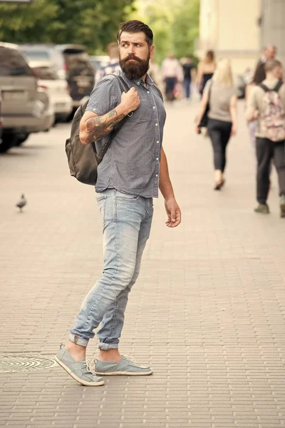 Hipster vistiendo mochila urbana calle fondo. El barbudo viaja con la mochila. Un tipo explorando la ciudad. Un turismo cómodo. Vacaciones de verano. Concepto de turismo. Mochila para viajes urbanos — Foto de Stock