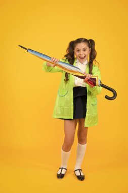 Suya dayanıklı giysiler. Yağmur geçirmez kıyafetler. Yağmur bitti. Yağmur yağıyor. Yağmurlu günleri bekliyorum. Şemsiye ile Schoolgirl şık küçük çocuk su geçirmez yağmurluk giymek. Sonbahar yağmuru. Okula gitmek