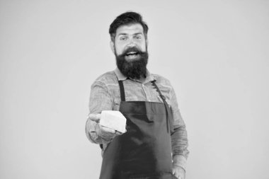 Peynir al. Gurme ürünü. Süt ürünleri sütten türetilmiştir. İnternetten alışveriş. Diyet ve beslenme. Peynir yapma konsepti. Peynir üreticisi. Önlüklü sakallı adam peyniri tut. Dükkan personeli mesleği