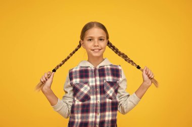 Uzun saçlı çocuk. Küçük kız kareli gömlek. Uluslararası Çocuk Günü 'n kutlu olsun. Küçük kız sarı arka plan. Keyif konsepti. Pozitif titreşimler. Samimi duygular. Eğleniyorum. Güzel örgülü kız.