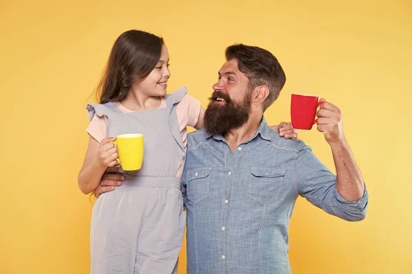 Bearded man and happy girl holding mugs. Father and daughter hot drink. Drink water. Drink fresh juice. Breakfast concept. Good morning. Having coffee together. Healthy lifestyle. Family drinking tea — Stock Photo, Image