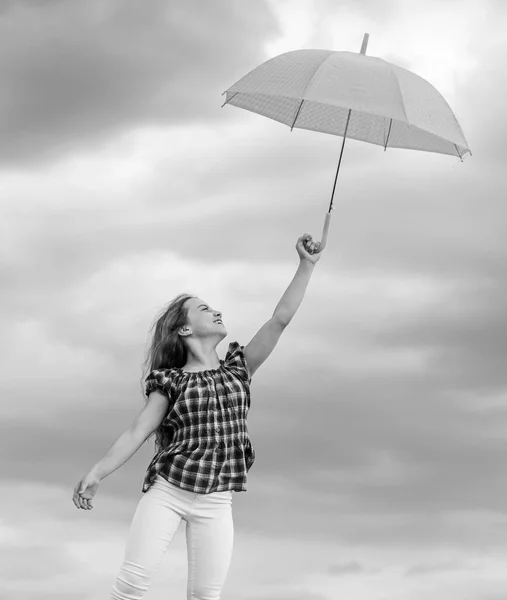 Niño despreocupado al aire libre. Libertad y frescura. Concepto anti gravedad. Disfrutando de la facilidad. Pronóstico del tiempo. Listo para cualquier clima. Cambio de clima. Aire fresco. Chica con paraguas cielo nublado fondo — Foto de Stock