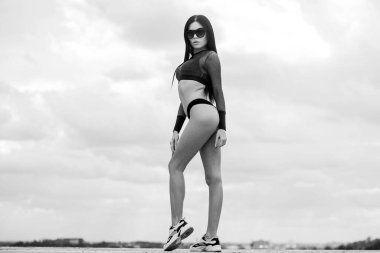 İnce bel ve uzun bacaklar seksi kalçalar. Sportif kız mükemmel vücut. Spa tesisi. Seksi kadın vücudu. Çekici, seksi, gökyüzü arka planı pozu veren bir kız. En iyi kıvrımlarını sergiliyor. Kalça kadın bikini giyiyor.