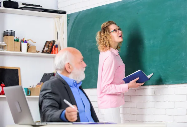 Confident girl. teacher works with laptop in classroom. student and tutor with laptop. senior teacher and woman at school lesson. student girl with tutor man at blackboard. pass exam. teachers room — Stock Photo, Image