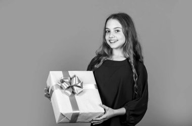 Neşeli çocuk büyük bir hediye kutusu tutuyor. Mutlu yıllar. Noel hediyesini aç. Noel partisi havası. Onun için doğum günü hediyesi. Alışverişten sonra küçük kız. Boks günü konsepti. Tatil için hazır