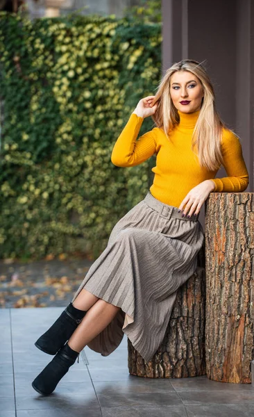 trendy girl wear corrugated skirt. pleated skirt collection. woman warm autumn skirt sit outdoor. relax while walking. enjoy casual day. Clothing features pleats. must-have skirt