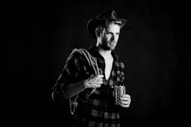 Şerif kavramı. Alkol içen vahşi bir kovboy. Batı kültürü. Şapka tutan ip ve matara giyen adam. Amerikan kovboyunun kementi. Yakışıklı, traşsız, siyah bir kovboy. Batı yaşamı