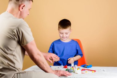 Babasıyla oynayan küçük bir çocuk. Gelecekteki kariyerim. çocukluk. Ebeveynlik. Aile doktoru. İlaç ve sağlık. Babası steteskoplu mutlu bir çocuk. Baba oğul tıp üniforması giyiyorlar. Saf mutluluk.