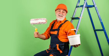 Gerçek inşaat işçisi. Son sınıf öğrencisi merdivende paten kullanıyor. Apartmanda çalışıyorum. Zanaatkar Boya Pateni. Ev boyama ve yenileme işi. Tamir aletleri yapıyorum. İnşaat alanında çalışan bir ressam.