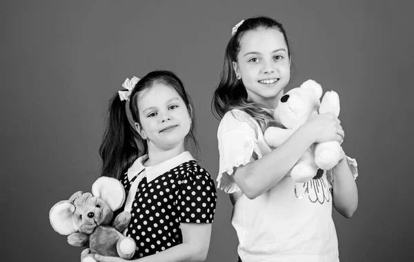 Sisters or best friends play with toys. Sweet childhood. Childhood concept. Kids adorable cute girls play with soft toys. Happy childhood. Child care. Excellence in early childhood education
