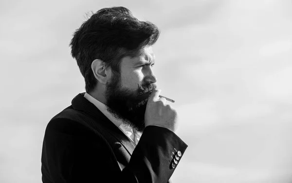 Hipster barbu fumant cigarette fond bleu ciel. Guy avec cigarette profiter de l'influence de la nicotine. La vérité sur le plaisir de fumer et la dépendance à la nicotine. Homme avec barbe et moustache tenir cigarette — Photo