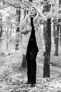 Bir yıldız gibi rockçı ceketi nasıl giyilir? Puffer moda konsepti. Kadınlar kalın pembe ceket giyer. Sonbahar ormanlarında şık sarışın kız yürüyüşü. Herkesin giymesi gereken ceketler. Almak için en iyi kabarık ceketler