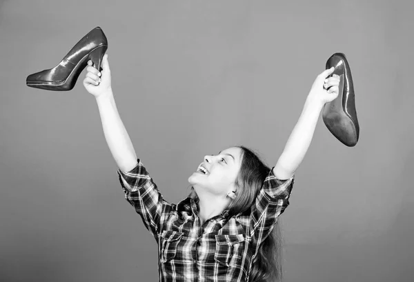 Vorrei crescere piu 'in fretta. Buona infanzia. Impressionanti scarpe a stiletto rosse. Un ragazzino fashionista con i tacchi alti. Tacchi alti glamour. Ogni ragazza sogna tacchi alti alla moda. Scarpe negozio — Foto Stock