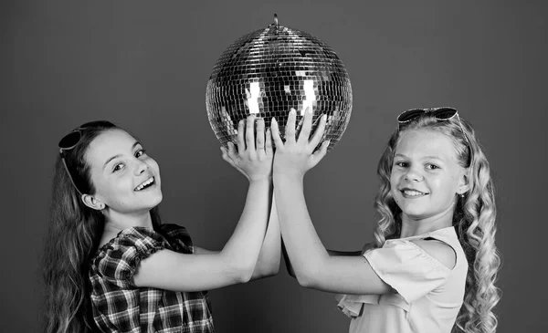 Holiday celebration. Entertainment concept. Sisters friends with disco ball. Lets start party. Cheerful kids hold disco ball. Disco dances. Retro music. Mirrors reflecting lights disco atmosphere