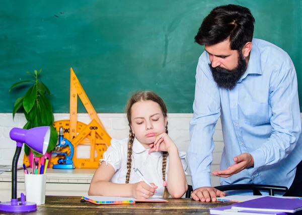 Haciendo papeleo de tareas caseras. Niño cansado estudio desmotivado aprender. Clases privadas. Educar en casa con padre. Profesora de escuela y colegiala. Hombre barbudo pedagogo. Pedagogo estricto. Habilidades pedagógicas —  Fotos de Stock