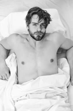 Yakışıklı adam esniyor ve kollarını kaldırıyor. Neşeli genç adam sabah uyuduktan sonra uyanıyor. Sabah umudu.