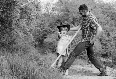 Doğada yaşayan küçük bir çocuk ve baba. Macera ruhu. Bahçedeki küçük yardımcı. Çocuk eğleniyor kovboy baba. Çiftlik ailesi. Ebeveyn çiftliğinde tatiller. Şirin bir kovboy. Çiftlikte hafta sonu