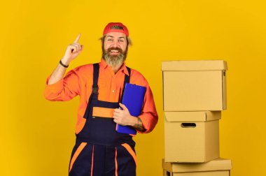 Bir fikrim var. Yeni daireye taşınıyorum. Yeni Yaşam Dalgası. Aletler için kutu. Taşınma konsepti. Ev taşıma günü. Alışılmışın dışında düşün. Hızlı teslimat konsepti. Kutuda liilersuit giyen bir adam.