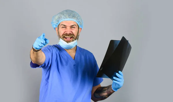 De dokter onderzoekt de röntgenfoto. Ziekenhuisspoedgeval. Dokter uniform. X-ray concept. Röntgenstraling. De dokter heeft foto 's van botten. Breuk en botschade. Schatting van de chirurg — Stockfoto