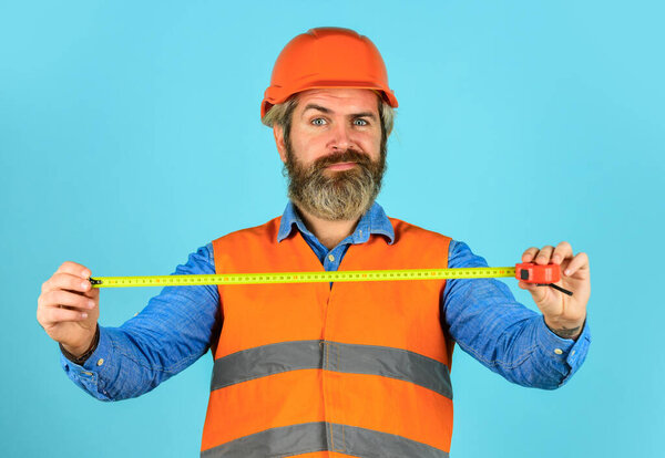 Hipster in hard hat. Make measurements apartment renovation. Safety Engineer Measure Acceptable Parameters. Builder with tape measure. Custom made furniture. Worker use tape measure. Size concept