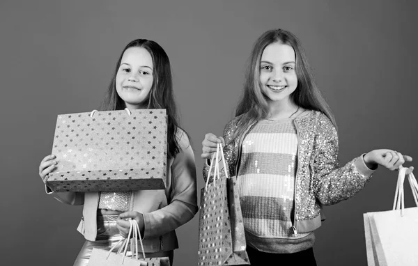 Hermandad y familia. ahorros en compras. Ventas y descuentos. Moda infantil. Fondo azul. Chicas pequeñas con bolsas de compras. Niños felices. Hermanitas. Concepto de hermandad. Día de familia — Foto de Stock