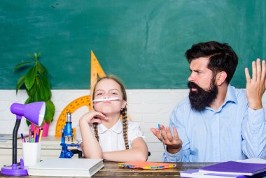 Evde eğitim kavramı. Biyoloji kimya dersi. Okula dönüyorum. Matematik geometrisi. Eğitim ve bilgi. Baba ve kızı sınıfta çalışıyor. Sınıfında küçük bir kız olan sakallı bir öğretmen.