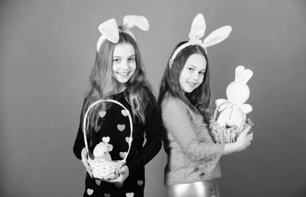 Tatil eğlenceli. Küçük çocuk bunny kulaklar Paskalya gününde giyiyor. Paskalya tavşanımı sepetler içinde tutan kız çocuk. Paskalya tavşanı oyuncaklar hediyeler getiren küçük çocuklarla. Paskalya kutluyor mutlu çocuk — Stok fotoğraf