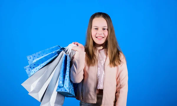 Happy child in shop with bags. Shopping day happiness. Buy clothes. Fashionista addicted buyer. Fashion boutique. Birthday girl shopping. Fashion trend. Fashion shop. Little girl with bunch packages — Stock Photo, Image