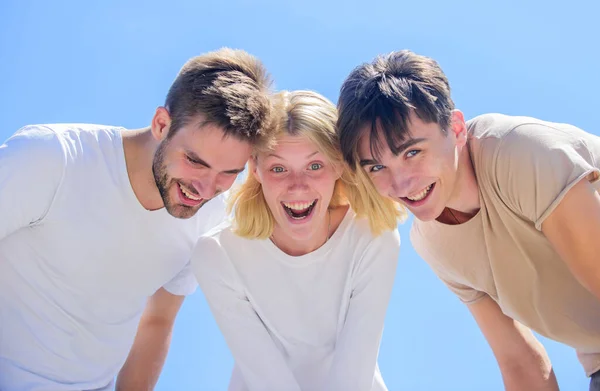 Felicidad en la unidad. Mente abierta para la felicidad. Mira aquí. Los jóvenes despreocupados pasan el rato juntos. Ve algo adorable. Felicidad. La gente del grupo emocionada mira hacia abajo. Mujer y hombres feliz cielo fondo — Foto de Stock