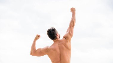 Harika görünüyor. Başarılı bir atlet. Zafer ve başarı. Şampiyon ve kazanan konsepti. Adam başarıyı kutluyor. Vücut geliştirici güçlü kaslı vücut güçlü ve üstün arka görüş hissediyor. Başarı elde et