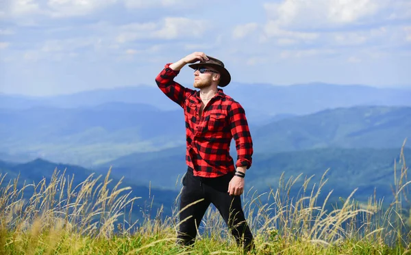 inspiration search. man on mountain landscape. camping and hiking. countryside concept. farmer on rancho. travelling adventure. hipster sexy macho man in checkered shirt. cowboy in hat outdoor