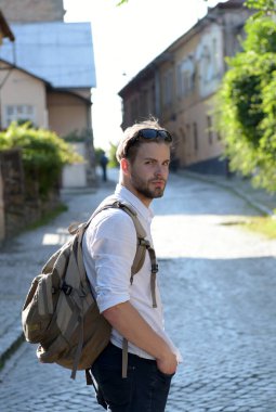 Sırtında sırt çantası olan sakallı bir adam. Sırt çantalı öğrenci