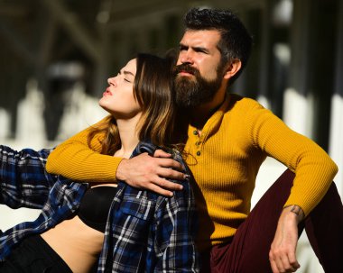 Arka planda rahat yüzlü kadın ve erkek.