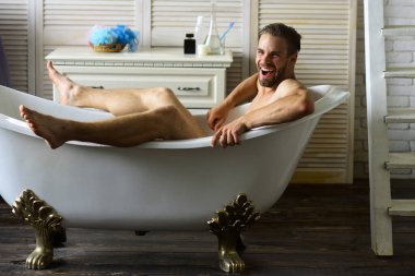 Banyodaki adam geniş gülüyor, seçici odaklanıyor.