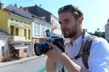 Turist şehir manzarasının fotoğrafını çeker. Sakallı adam