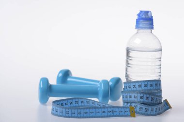 Mavi şeritle sarılmış halterler ve su şişeleri.