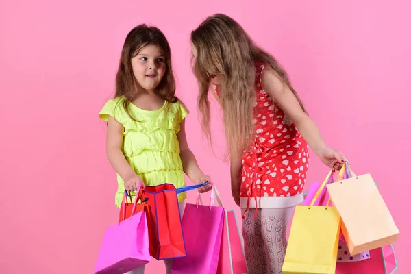 Liseli kızlar pembe, kırmızı ve sarı paketleri tutar. — Stok fotoğraf