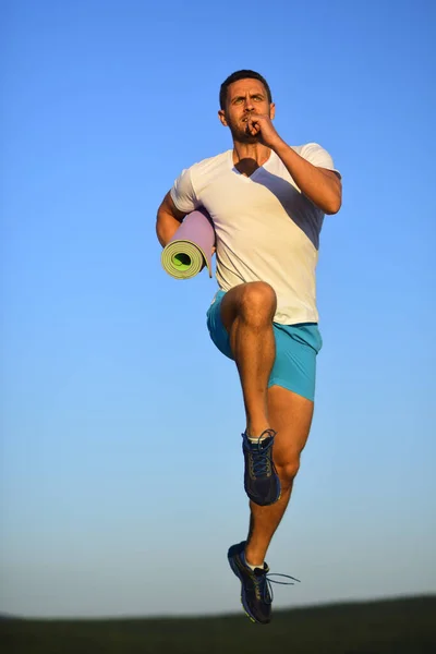 Deportista lleva camiseta blanca y pantalones cortos azules funciona . — Foto de Stock