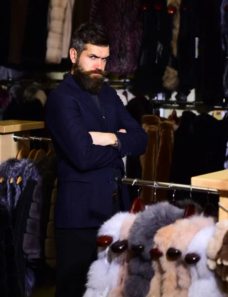 Man met een strak gezicht houdt armen gekruist in de buurt van harige jassen. — Stockfoto