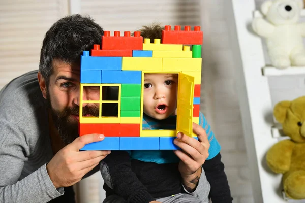 Father and son with surprised faces look through window — Stock Photo, Image