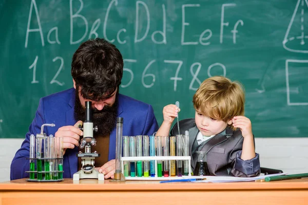 Eğitim motivasyonu. Bilim adamının elinde deney tüpleriyle matara. Tahtalı eğitim odası. Oğlu ve babası okulda. Bilgelik. Okula dönelim. Küçük çocuk ve öğretmen adam. — Stok fotoğraf