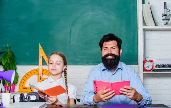 Man bebaarde pedagoog studie samen met kind. Studeren is leuk. Leraar en schoolmeisje. Taak met succes uitgevoerd. Thuisonderwijs met vader. Help met studeren. Discipline opvoeding. De les is afgelopen — Stockfoto