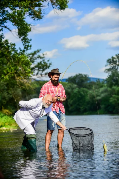 Podemos fazê-lo. Conceito de captura e pesca. Dois amigos a pescar juntos. passatempo de peixe de mosca de homem de negócios. pesca da reforma. pescadores felizes. Bom lucro. aposentado pai e maduro barbudo filho — Fotografia de Stock