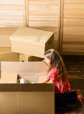 İçine bak. Mutlu çocuk karton kutusu. Odanın tamiri. Yeni daire. Taşınan kutuları açıyorum. Yeni bir yaşam alanı satın almak. Karton kutular yeni bir eve taşınıyor. Kutudaki küçük mutlu kız