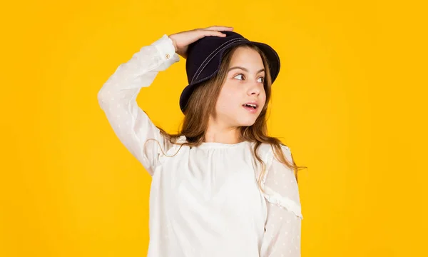 Τάση Παναμά. Ατομικό στυλ. Κορίτσι φορούν καπέλο κίτρινο φόντο. Ευτυχισμένο παιδί με καπέλο. Αξεσουάρ μόδας. Συλλογή καλοκαιρινών αξεσουάρ. Τα μακριά μαλλιά του παιδιού φοράνε καπέλο. Στο κατάστημα αξεσουάρ. Έμπνευση εξοπλισμού — Φωτογραφία Αρχείου