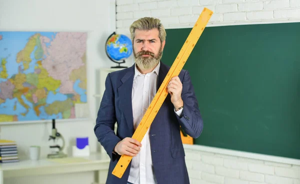 Modern teaching method. Each School defines final examination sessions. Modern teacher lesson. Study and education. Modern school. Knowledge day. Handsome bearded man in classroom chalkboard