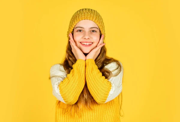 쾌활 한 어린이는 모자를 쓰고 좋아 하는 스웨터를 입는다. 어린 시절의 행복. 노란 배경의 10 대 소녀. 뜨개 질하는 여자 애. 아이들의 미와 패션. 겨울에는 따뜻 해집니다. 추운 일기 예보 — 스톡 사진
